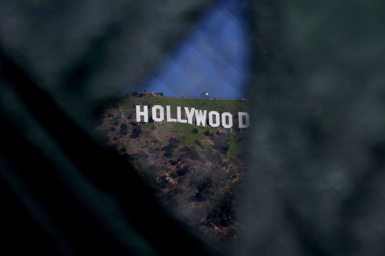 The Hollywoods sign seen through a gap in a fence