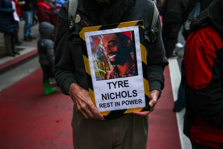 A protestor holds a sign with a photo of Tyre Nichols