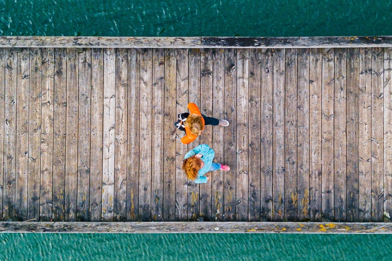 Two women walking side by side on jetty, Valdemurio Reservoir, Asturias, Spain