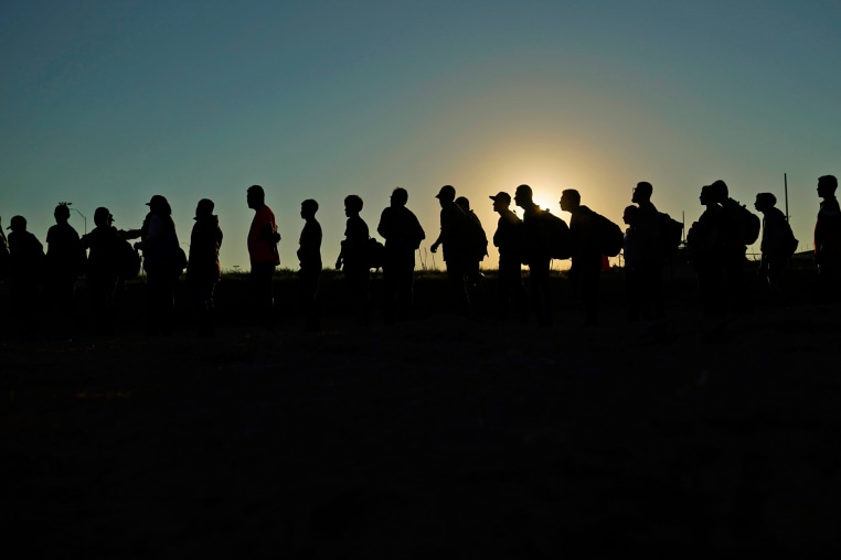 Migrants who crossed the Rio Grande and entered the U.S. from Mexico are lined up for processing by U.S. Customs and Border Protection on Sept. 23, 2023, in Eagle Pass, Texas. 