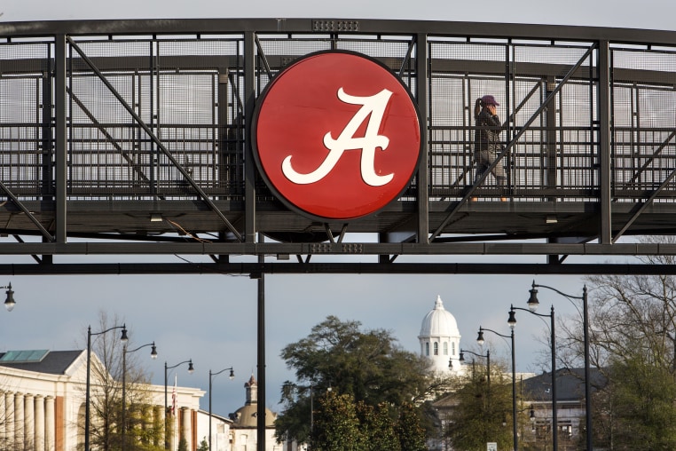  Students walk over a footbridge connecting new residential buildings with the older part of campus at the University of Alabama