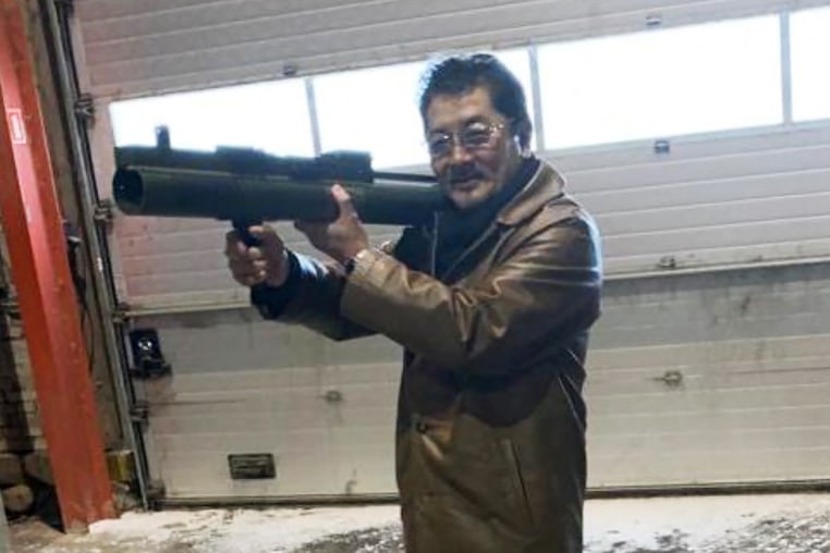 Takeshi Ebisawa poses with a rocket launcher during a meeting with an informant at a warehouse in Copenhagen