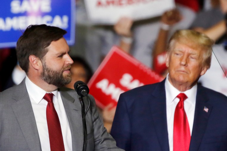 Donald Trump looks at JD Vance at a campaign rally.
