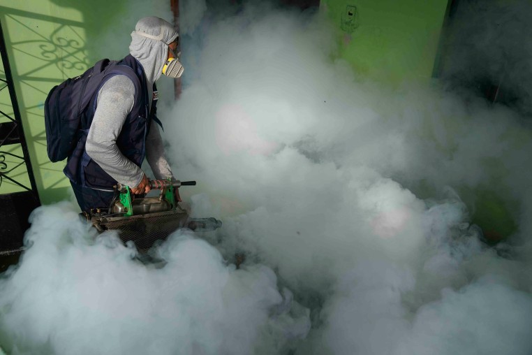 A health worker fumigates for mosquitoes inside a home to help mitigate the spread of dengue in the Las Penitas area of Talara, Peru on March 1, 2024. 