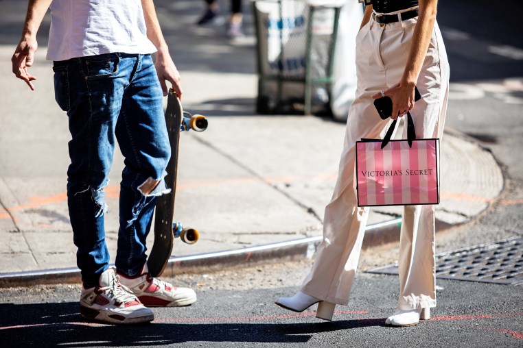 A pedestrian carries a Victoria's Secret shopping bag while waiting to cross a street in New York.