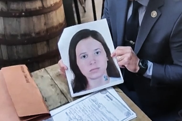NYPD Detective Ryan Glas holds a digital composite photo of Patricia Kathleen McGlone.