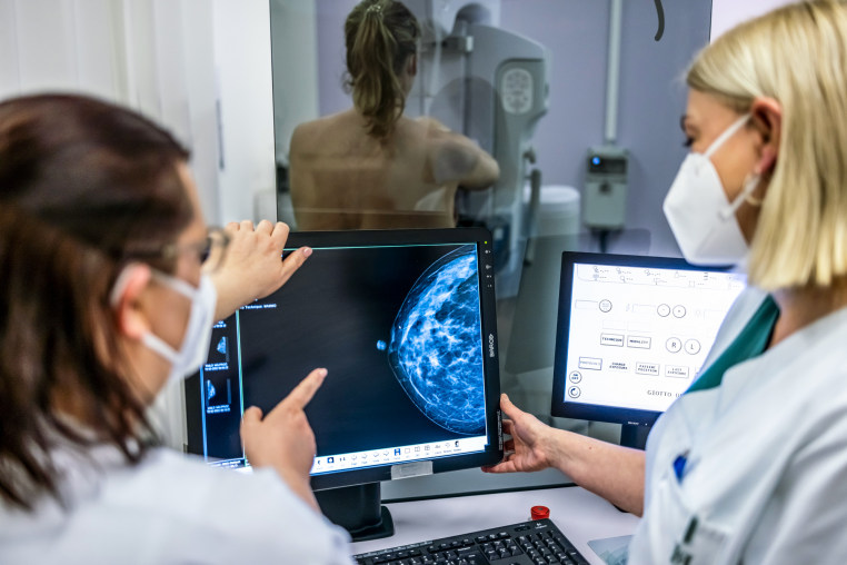 Medical personnel use a mammogram to examine a woman's breast for breast cancer.