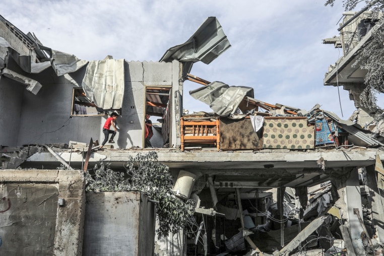 Gazans inspect a destroyed house 