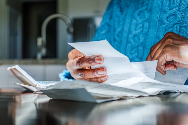 Person reviews receipts at kitchen table