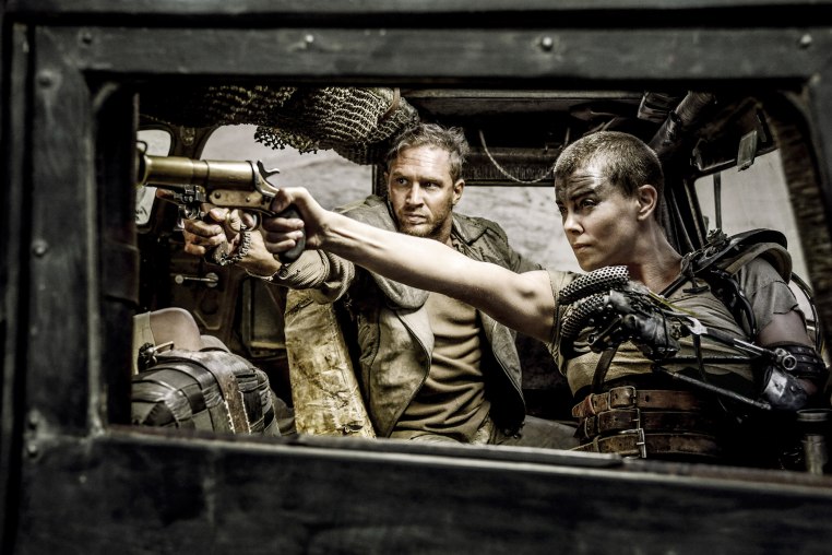 Charlize Theron and Tom Hardy pointing guns in a scene from the movie
