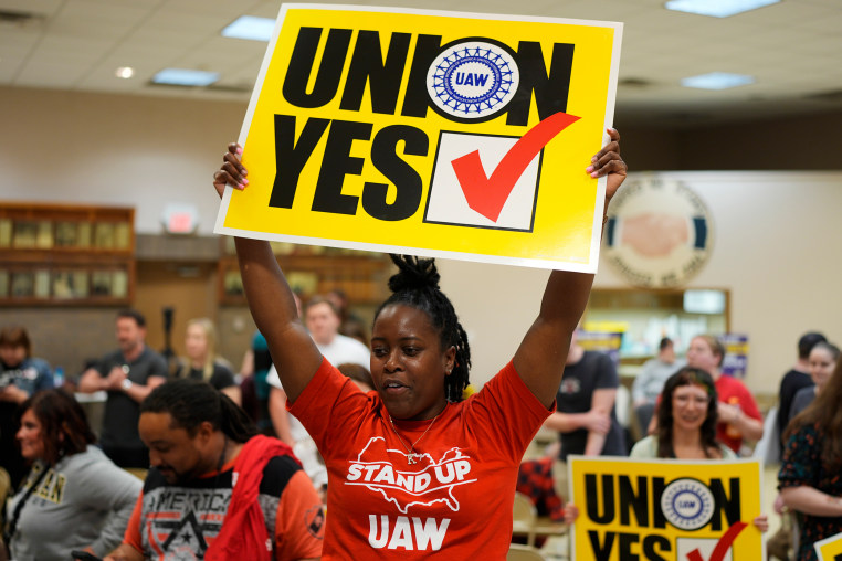 A woman holds a sign that says "Union Yes"