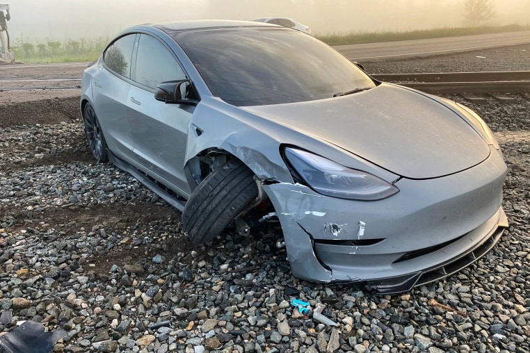 A Tesla with a damaged bumper and front right wheel.