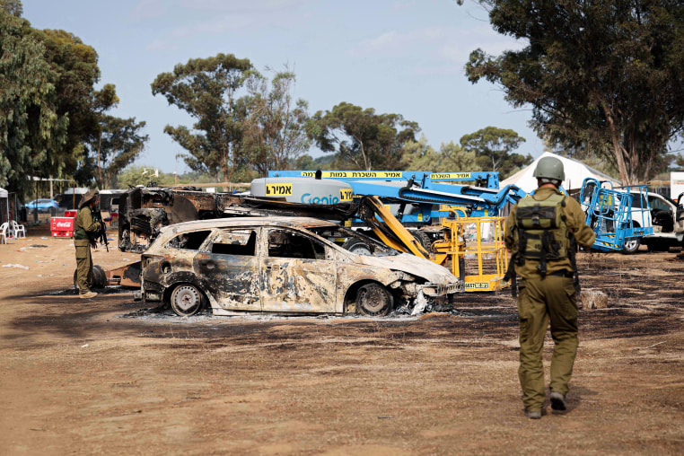 Israeli troops inspect the ravaged site of the attack.