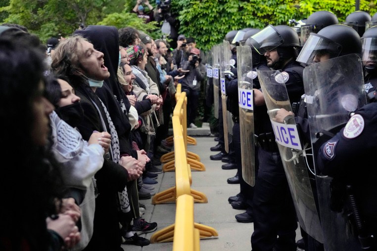 Pro-Palestinian protesters chant at the University of Chicago police while being kept from the university's quad as the student encampment is dismantled on May 7, 2024