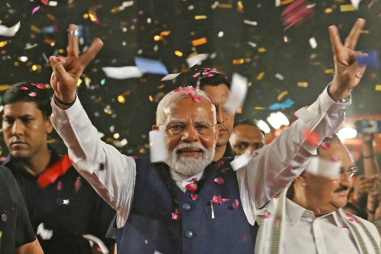 India's Prime Minister Narendra Modi flashes victory signs