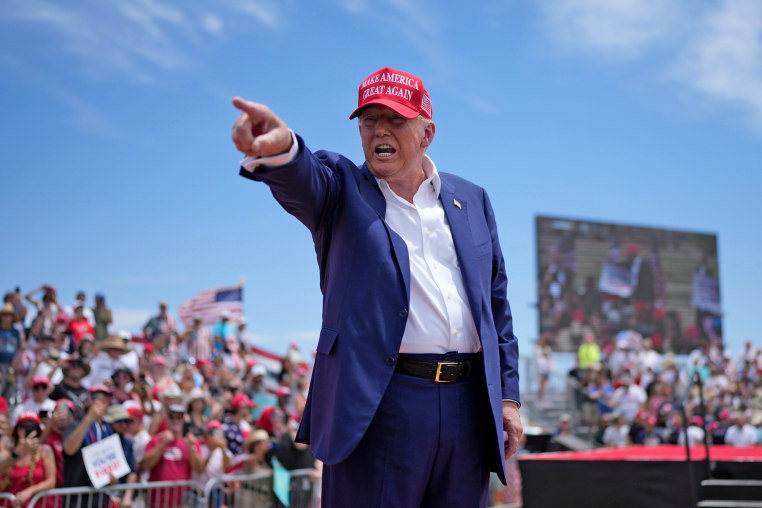Former President Donald Trump points to the crowd at a rallyh