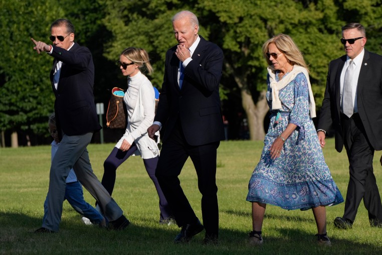 President Joe Biden, center, walks with his family on the grass at Fort Lesley J. McNair in Washington, D.C.