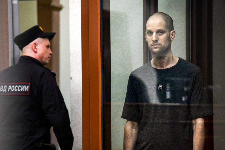 Evan Gershkovich stands listening to the verdict in a glass cage of a courtroom inside the building of "Palace of justice," in Yekaterinburg, Russia