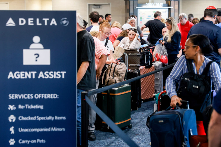 Travelers wait in line at the airport