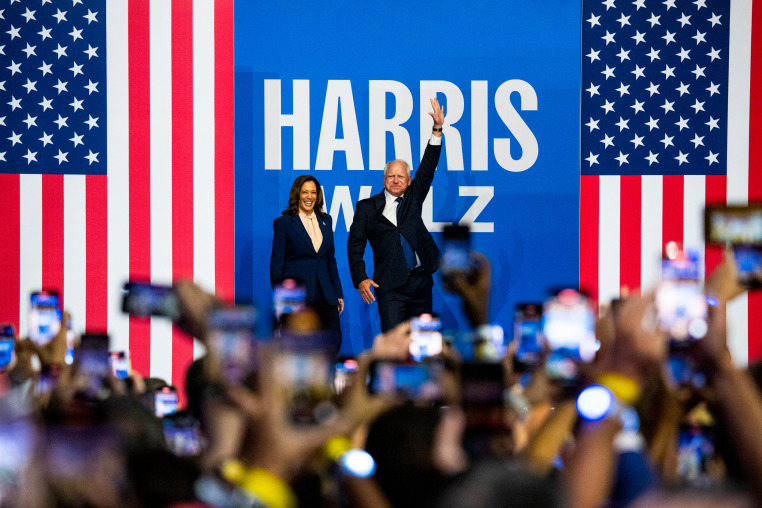 Kamala Harris and Tim Walz wave to the crowd