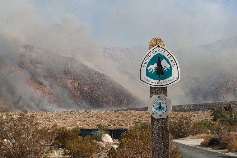 Smoke behind a sign that reads " Pacific Crest Trail"