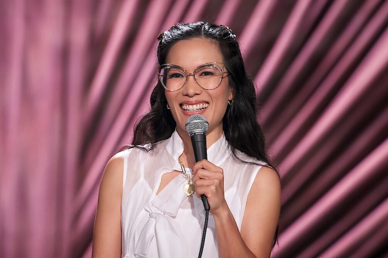 Ali Wong smiling and holding a microphone