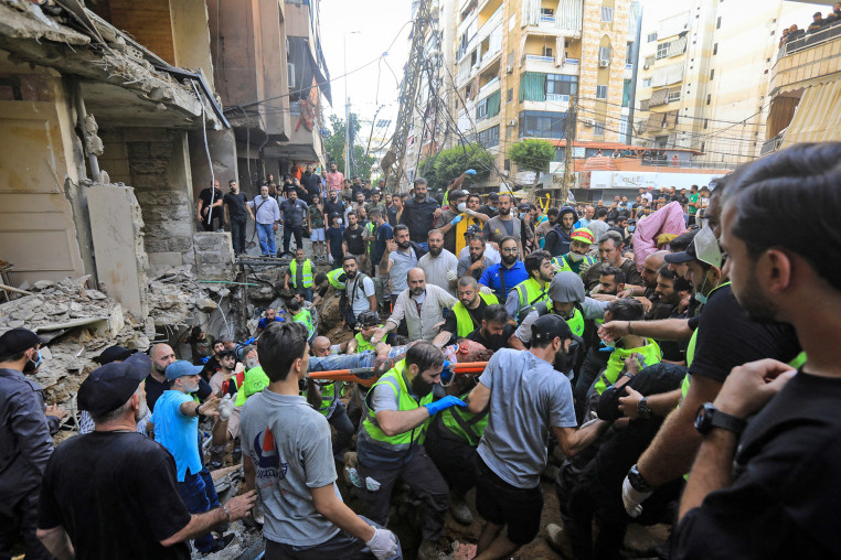 An injured man is evacuated from the scene of an Israeli strike in Beirut's southern suburbs on Sept. 20, 2024. 