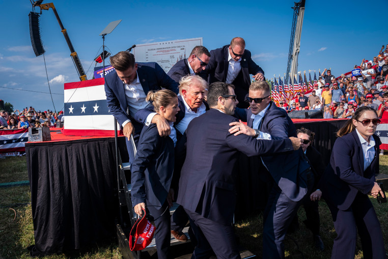 Donald Trump is carried away with blood on his face