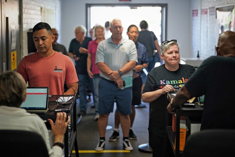People wait in line to vote on the first day of early voting in Virginia at a voting center in Manassas, Va.