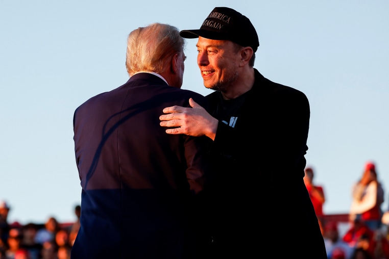 Elon Musk embraces Republican presidential nominee, and former President Donald Trump in Butler, Pa. on Oct. 5, 2024.