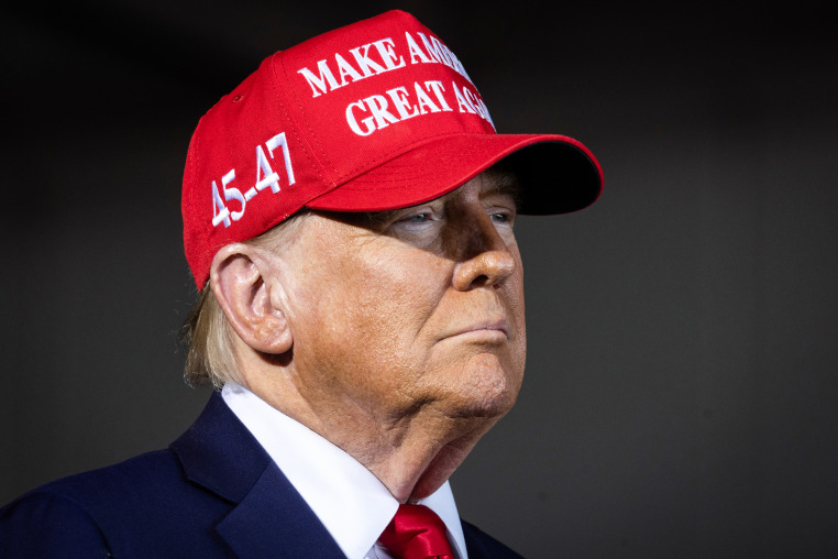 Donald Trump wears a red "Make America Great Again" hat