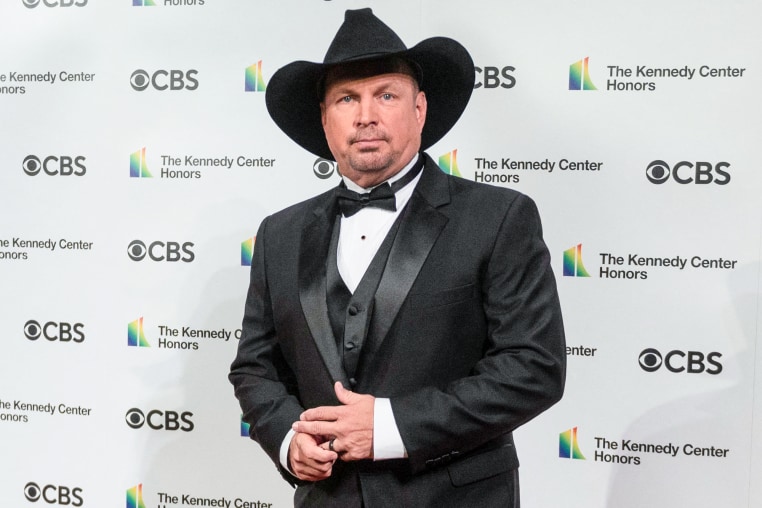 Garth Brooks stands for a photo at an event