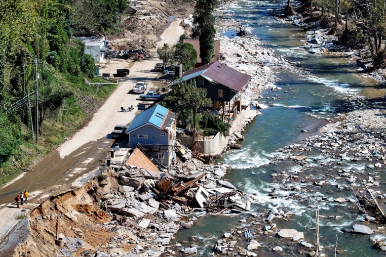 An aerial view of damaged housing near a river