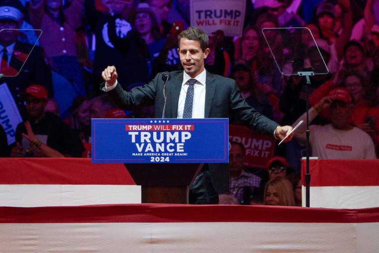 Tony Hinchcliffe speaks at a podium in a full stadium