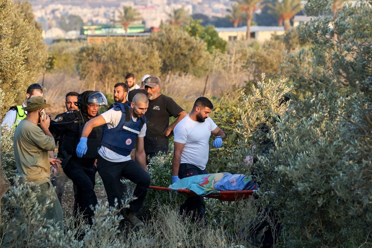 First responders carry the shrouded body of a woman who was killed when a rocket fired from Lebanon hit an area near Kiryat Ata in northern Israel's Haifa district on Oct. 31, 2024.