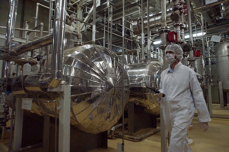 A security official in protective clothing walks inside a facility