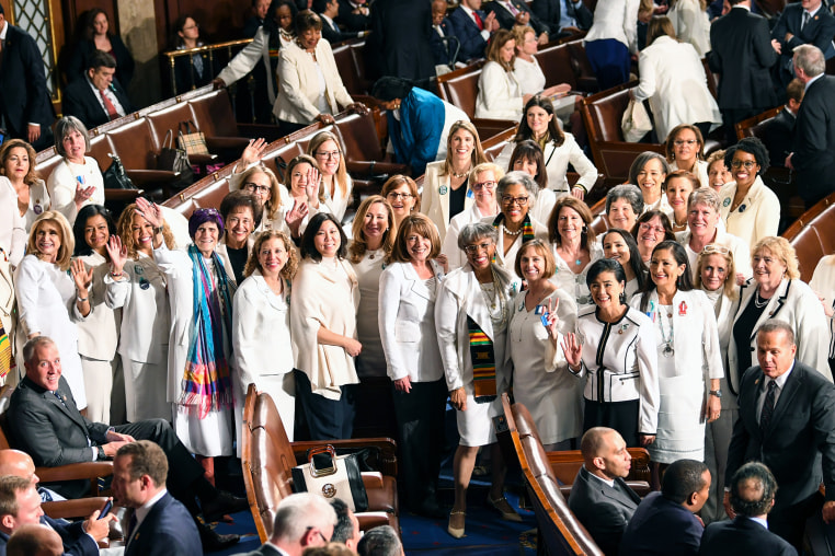 Female lawmakers dressed in white pose for a photo