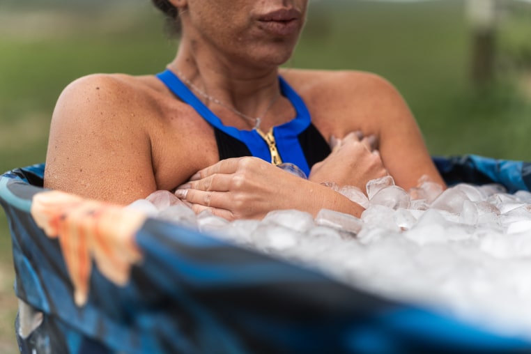 Female athlete taking ice bath for recovery after hard training session