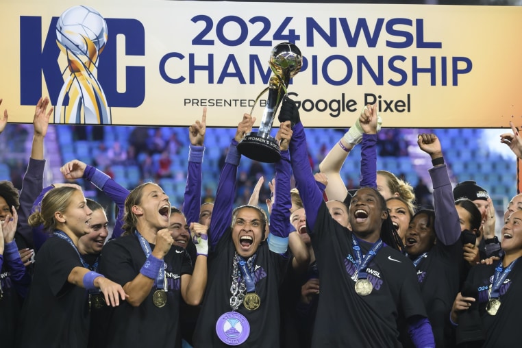 Orlando Pride forwards Marta, center, and Barbra Banda, right, lift the 2024 NWSL championship trophy together after defeating the Washington Spirit.