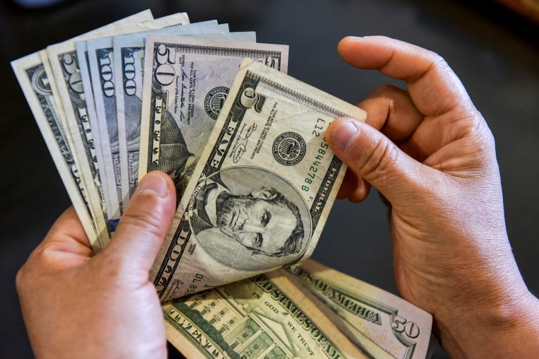 A person holds U.S. dollar bills in his hand on Sept. 6, 2023.