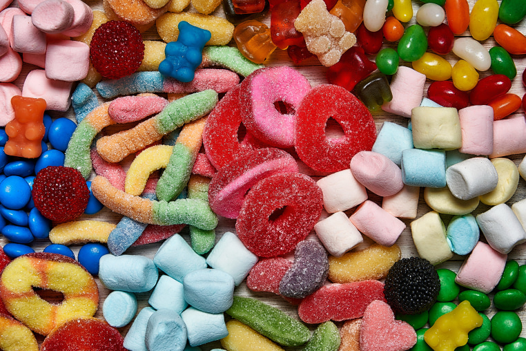 An assortment of colorful jellybeans, lollipops, candies and marshmallows.