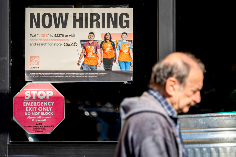 A "NOW HIRING" sign at a window.