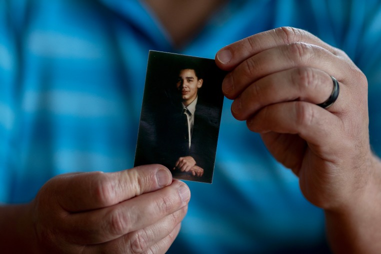 Hector Adames holds a small photo of Joshua Adames.