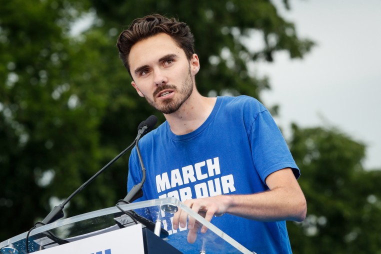 David Hogg speaks at a podium outside
