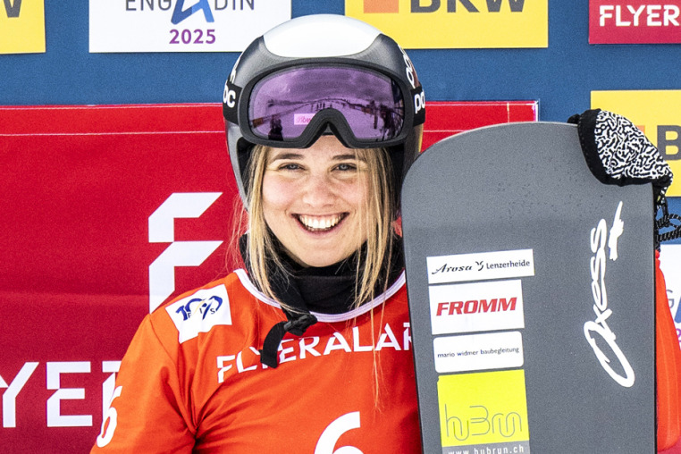 Sophie Hediger smiles and holds her snowboard outside