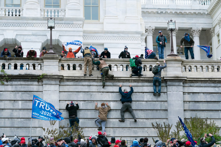 Trump supporters climb the west wall of the the Capitol