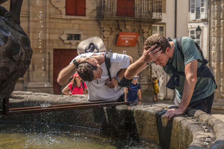 Visitors refresh themselves with water from a fountain.