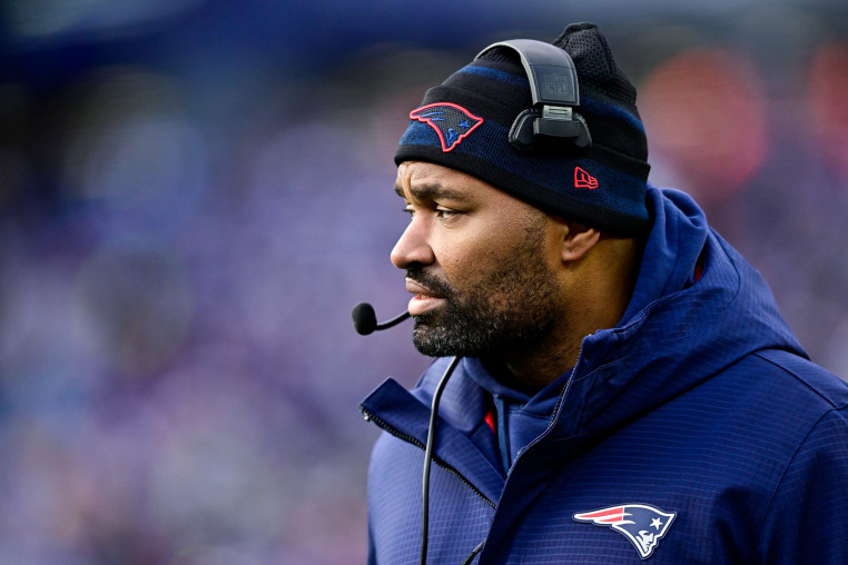 Jerod Mayo looks across the football field from the sidelines