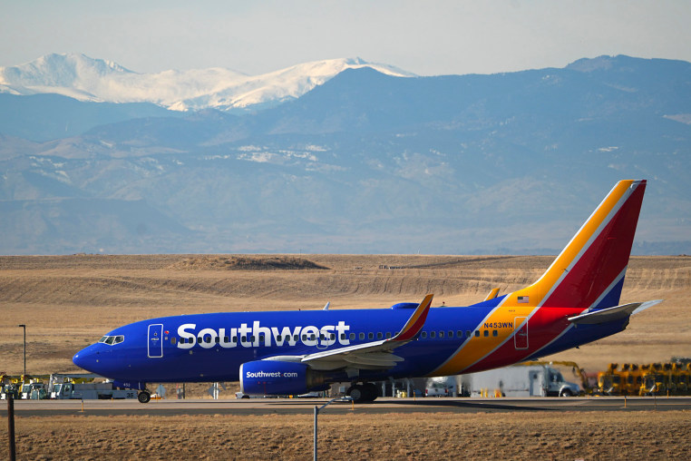 A Southwest Airlines plane taxis down a runway for take off at Denver International Airport.