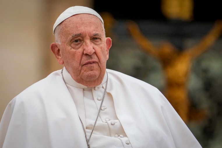 a close up of a man in a white robe and a cross